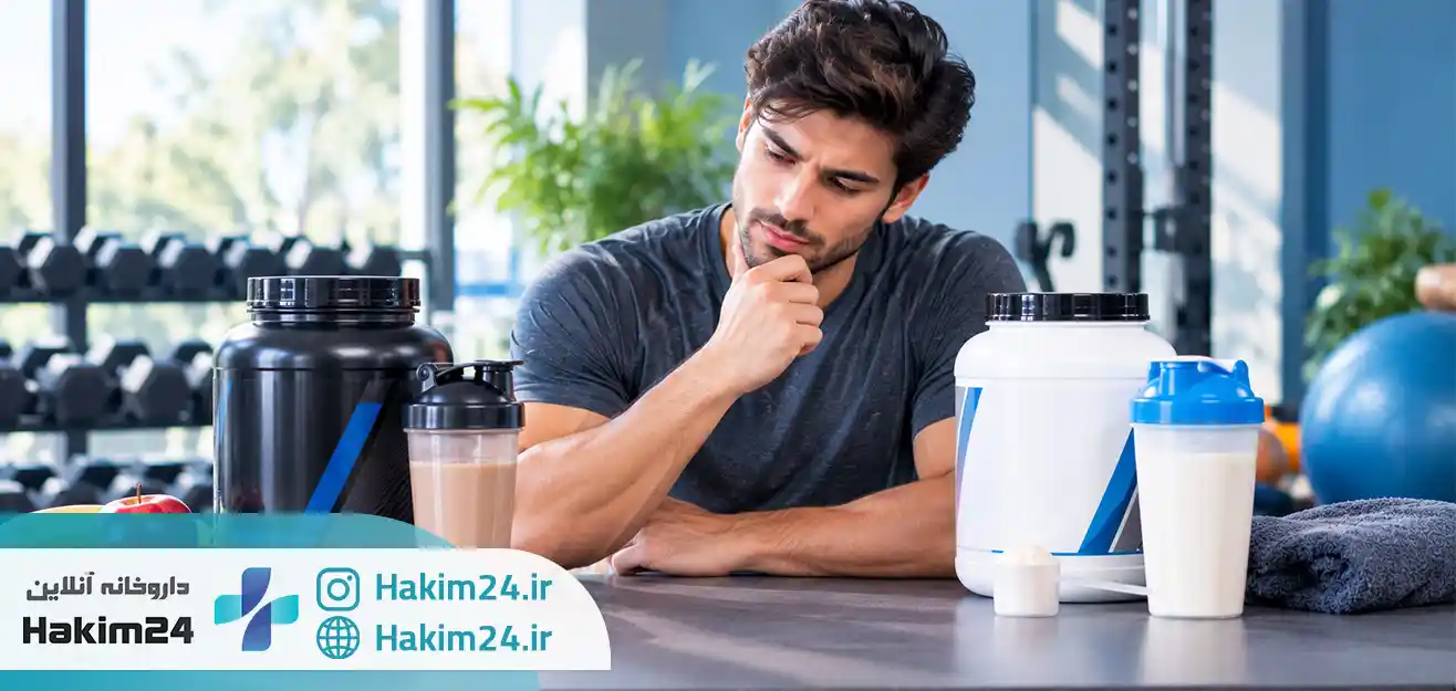 مرد ورزشکار در حال مقایسه مکمل های گینر و پروتئین وی در سالن ورزشی