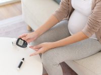 Pregnant woman checking blood sugar level by using Digital Glucose meter, health care, medicine, diabetes, glycemia concept